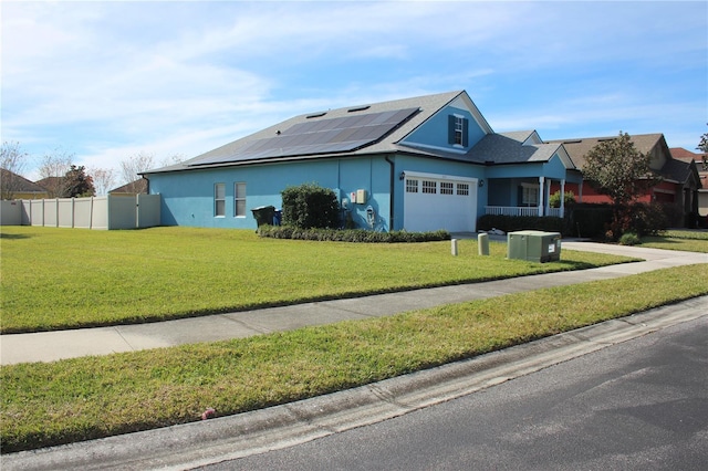 view of front of home with solar panels, a garage, and a front lawn