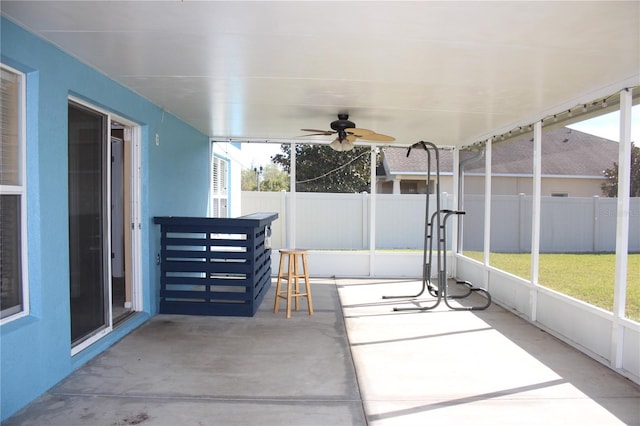 unfurnished sunroom with ceiling fan