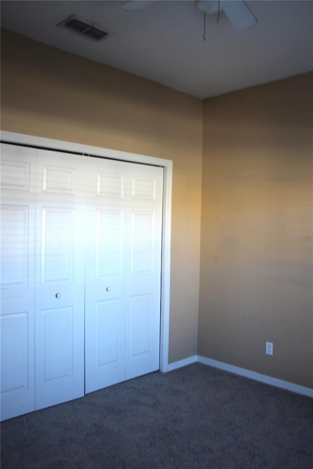 interior space with a closet and dark colored carpet