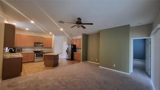 kitchen featuring stainless steel appliances, a center island, light carpet, and backsplash