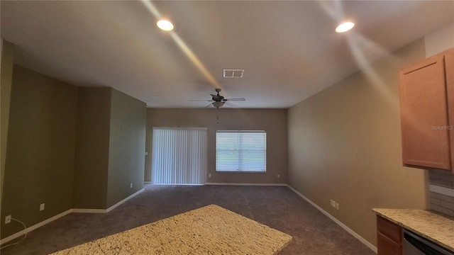 unfurnished living room featuring ceiling fan and dark carpet