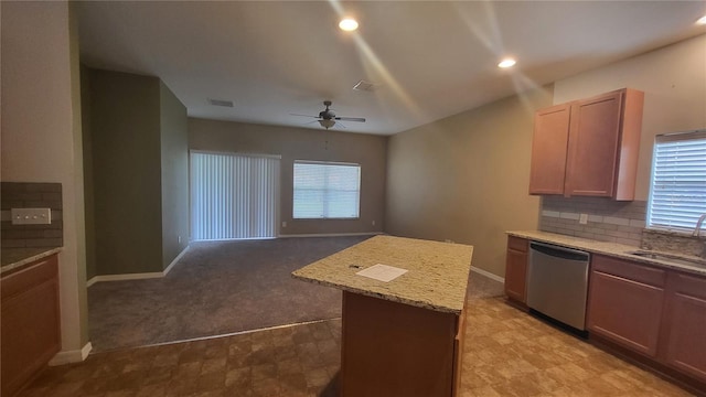 kitchen with sink, a center island, stainless steel dishwasher, ceiling fan, and decorative backsplash