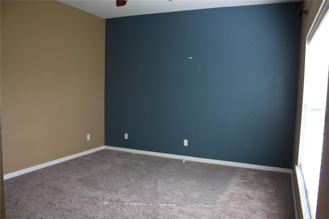 carpeted spare room featuring ceiling fan