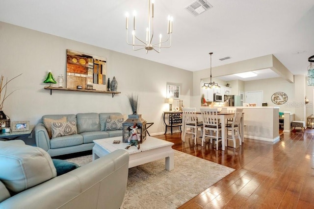 living room with an inviting chandelier and dark wood-type flooring