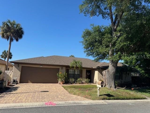 single story home featuring a garage and a front lawn