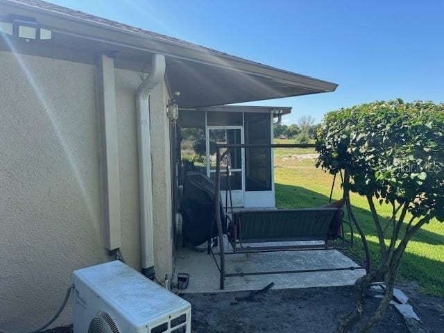 view of patio with ac unit and a sunroom