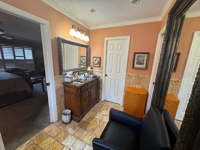 bathroom featuring a textured ceiling, tile walls, and crown molding