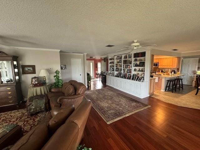 living room featuring ceiling fan, dark hardwood / wood-style flooring, and a textured ceiling