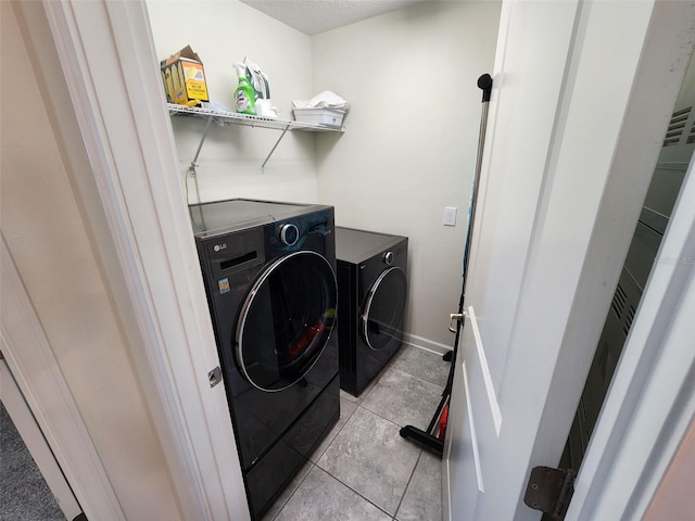 laundry area with light tile patterned floors and independent washer and dryer