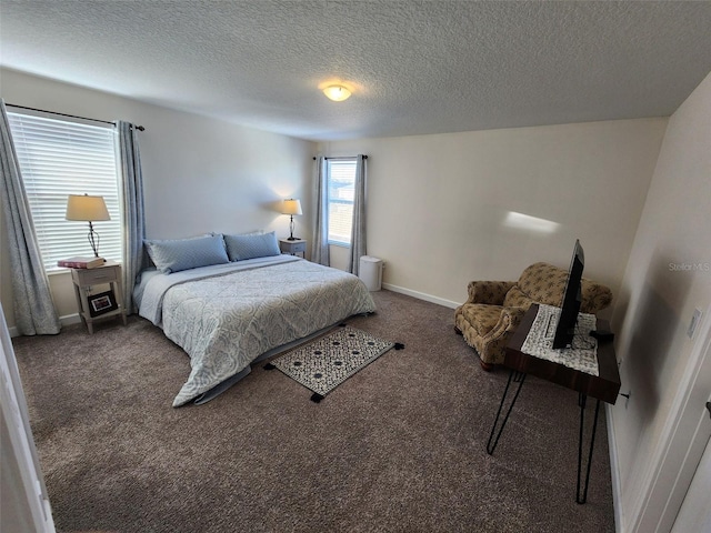 bedroom with a textured ceiling and dark colored carpet