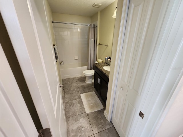 full bathroom featuring vanity, tile patterned floors, shower / bath combination with curtain, toilet, and a textured ceiling