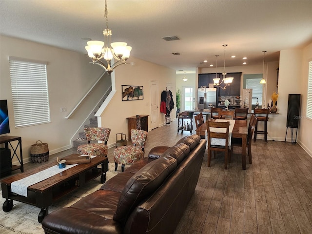 living room with wood-type flooring and an inviting chandelier