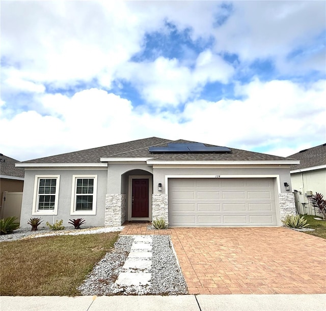 view of front of home featuring solar panels and a garage