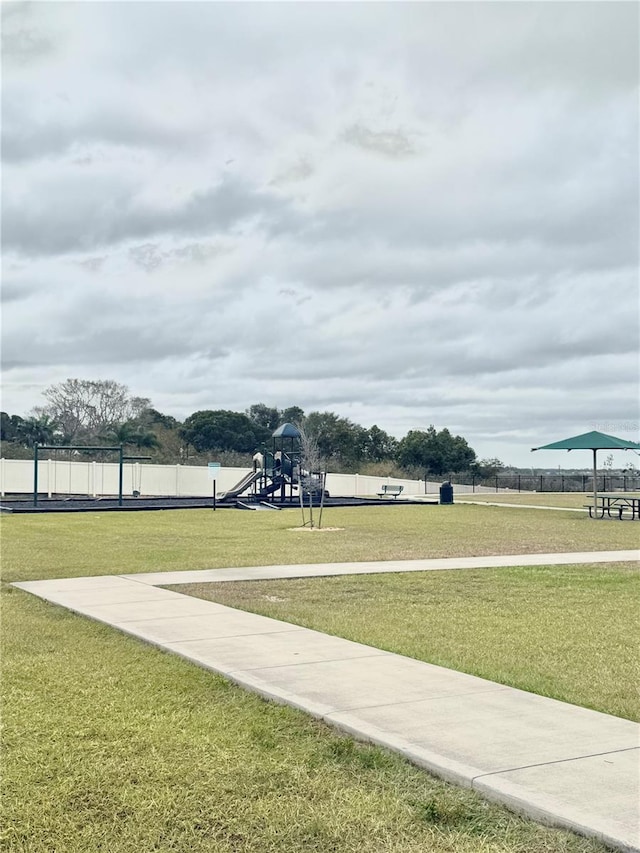 view of home's community featuring a yard and a playground