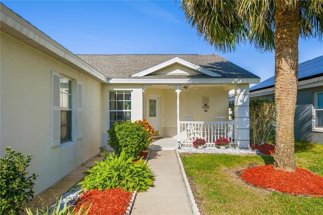 view of exterior entry featuring a yard and a porch