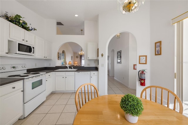 kitchen featuring white cabinets, white appliances, sink, and light tile patterned floors