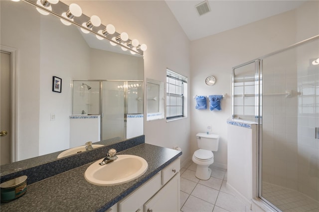 bathroom with tile patterned floors, toilet, vanity, and walk in shower