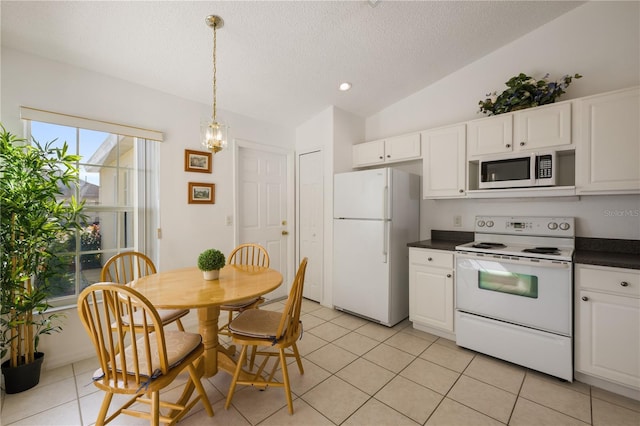 kitchen featuring lofted ceiling, white cabinets, and white appliances