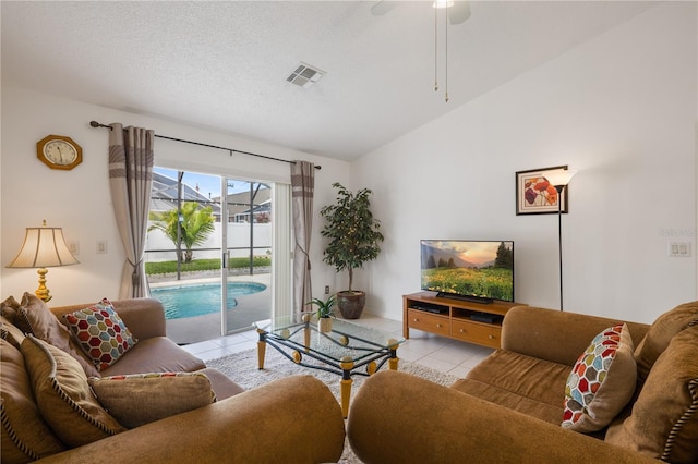 living room with ceiling fan, light tile patterned floors, and a textured ceiling