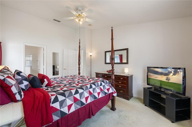 bedroom with light carpet, connected bathroom, and ceiling fan