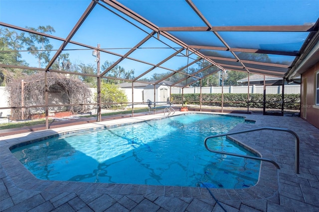 view of pool with a patio area, a lanai, and a storage shed