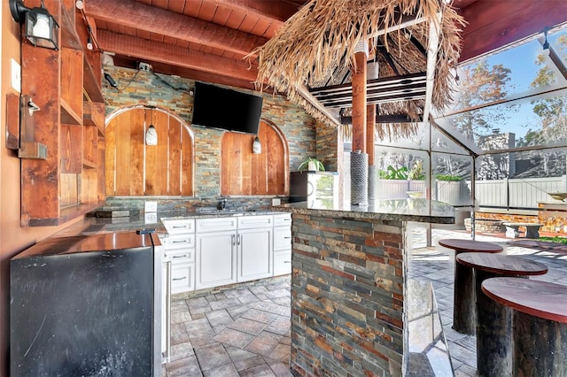 view of patio / terrace featuring a lanai and a wet bar