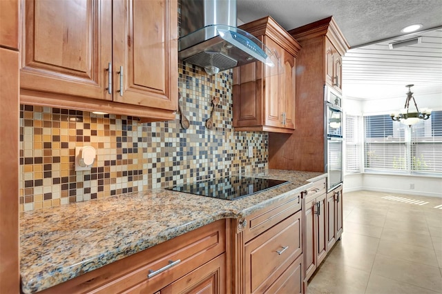 kitchen with light stone countertops, black electric stovetop, backsplash, wall chimney exhaust hood, and light tile patterned flooring