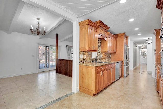 kitchen featuring light stone countertops, stainless steel appliances, sink, an inviting chandelier, and beamed ceiling