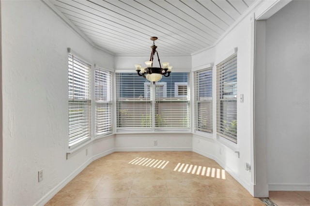 unfurnished dining area with an inviting chandelier, crown molding, and light tile patterned flooring