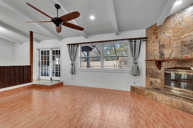 unfurnished living room featuring beam ceiling, ceiling fan, french doors, tile patterned flooring, and a fireplace