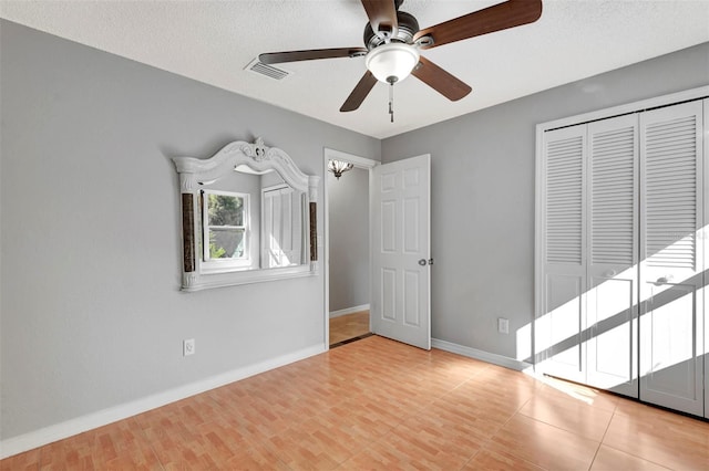 unfurnished bedroom featuring ceiling fan, a textured ceiling, and a closet