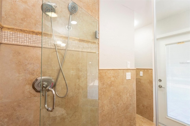 bathroom featuring tile walls and a shower with shower door