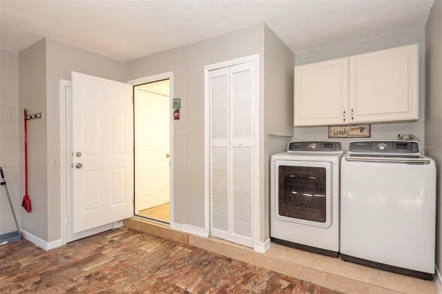 laundry room featuring separate washer and dryer and cabinets