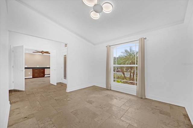 spare room with vaulted ceiling, ceiling fan, and crown molding