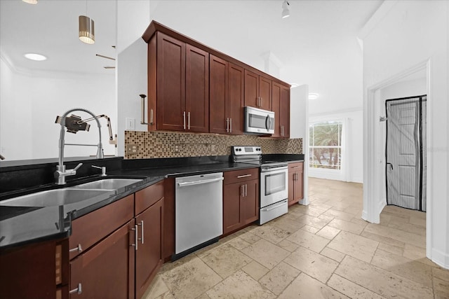 kitchen featuring decorative light fixtures, stainless steel appliances, tasteful backsplash, and sink