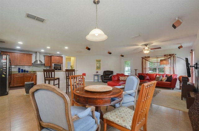 tiled dining area featuring ceiling fan and a textured ceiling