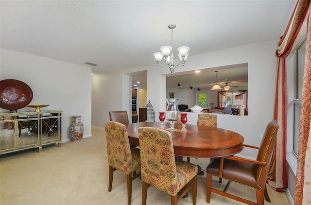 dining room featuring light colored carpet and an inviting chandelier