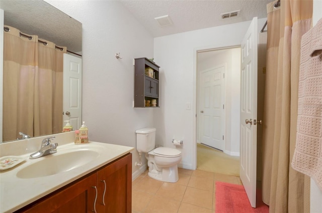 bathroom with toilet, a textured ceiling, vanity, and tile patterned floors