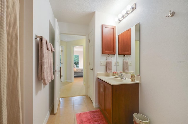 bathroom featuring a textured ceiling, vanity, and tile patterned floors