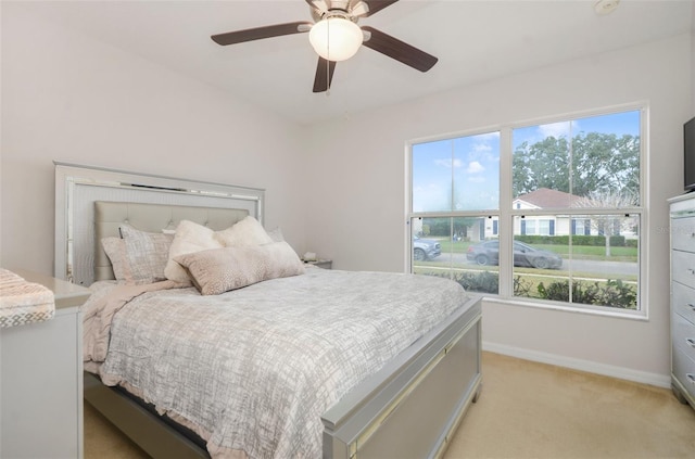 carpeted bedroom featuring multiple windows and ceiling fan