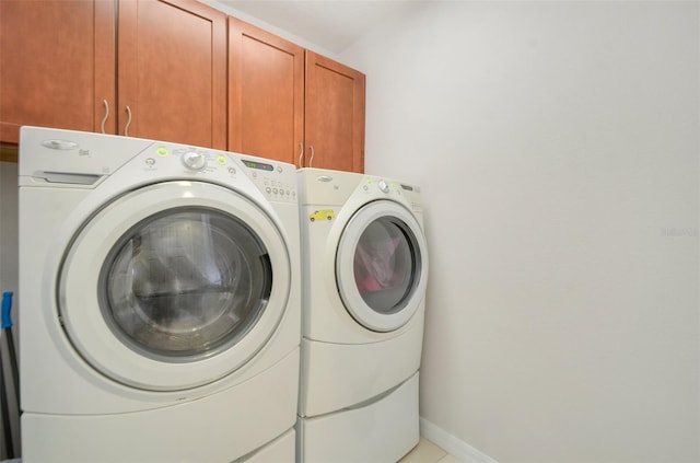 laundry room featuring light tile patterned flooring, cabinets, and washing machine and clothes dryer