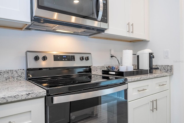 kitchen with white cabinetry, light stone countertops, and appliances with stainless steel finishes