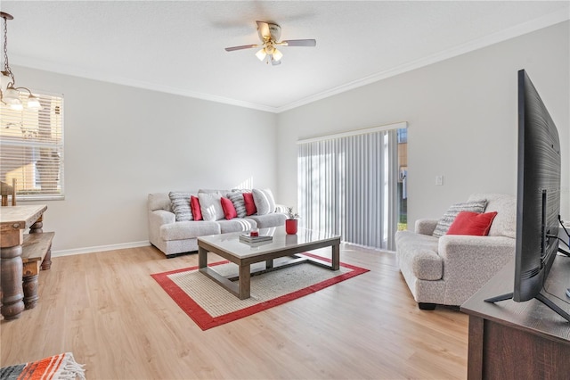 living room with ceiling fan with notable chandelier, light wood-type flooring, a wealth of natural light, and ornamental molding