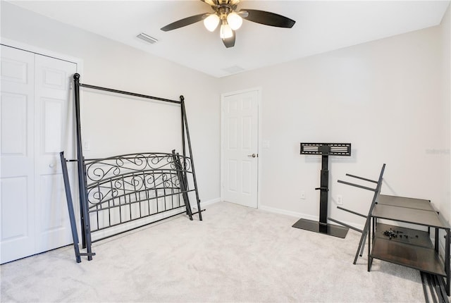 carpeted bedroom with ceiling fan and a closet