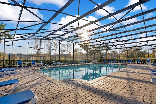 view of swimming pool with a patio area and a lanai