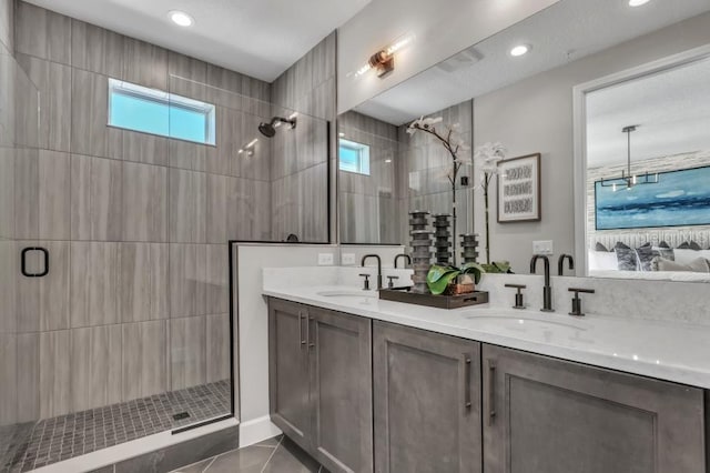 bathroom featuring a shower with shower door, tile patterned floors, and vanity