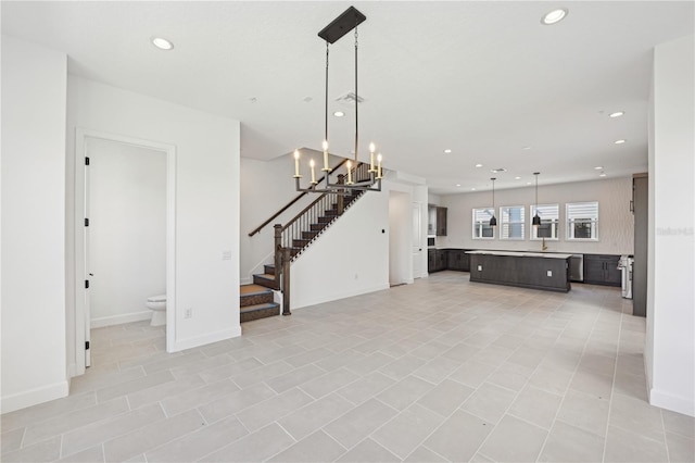 unfurnished living room featuring a chandelier and light tile patterned flooring