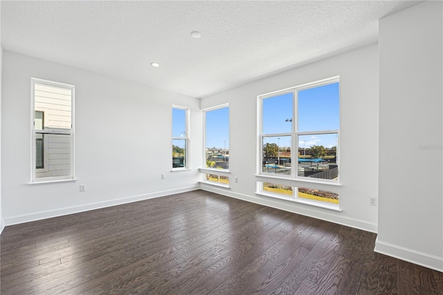 spare room with dark hardwood / wood-style flooring and a textured ceiling