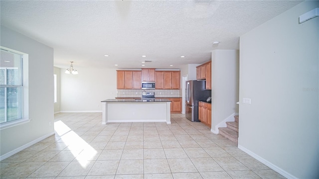 kitchen featuring appliances with stainless steel finishes, backsplash, a notable chandelier, and light tile patterned flooring