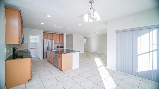 kitchen featuring stainless steel appliances, sink, decorative light fixtures, a center island with sink, and a chandelier